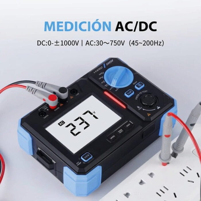 Probador de resistencia de aislamiento FNIRSI realizando una medición de voltaje AC/DC, mostrando las especificaciones de rango en pantalla y conectado a una regleta de enchufes.